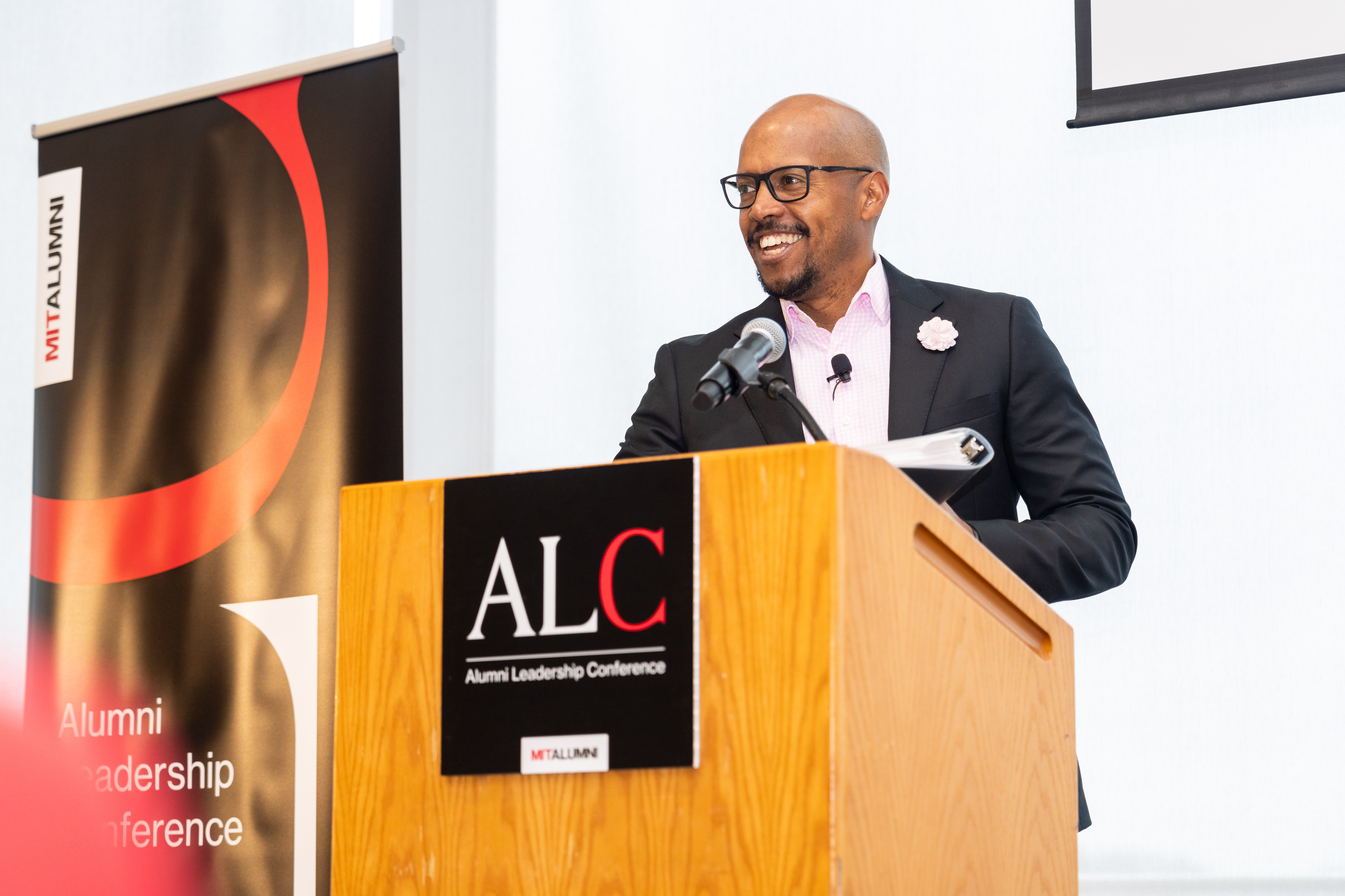 A photo of R. Robert Wickham standing at a podium with a sign that says ALC on the podium