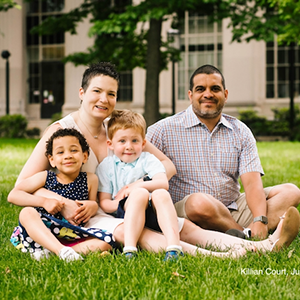 A photo of Benjamin O’Connor and Kristin Raven with two children sitting on a lawn