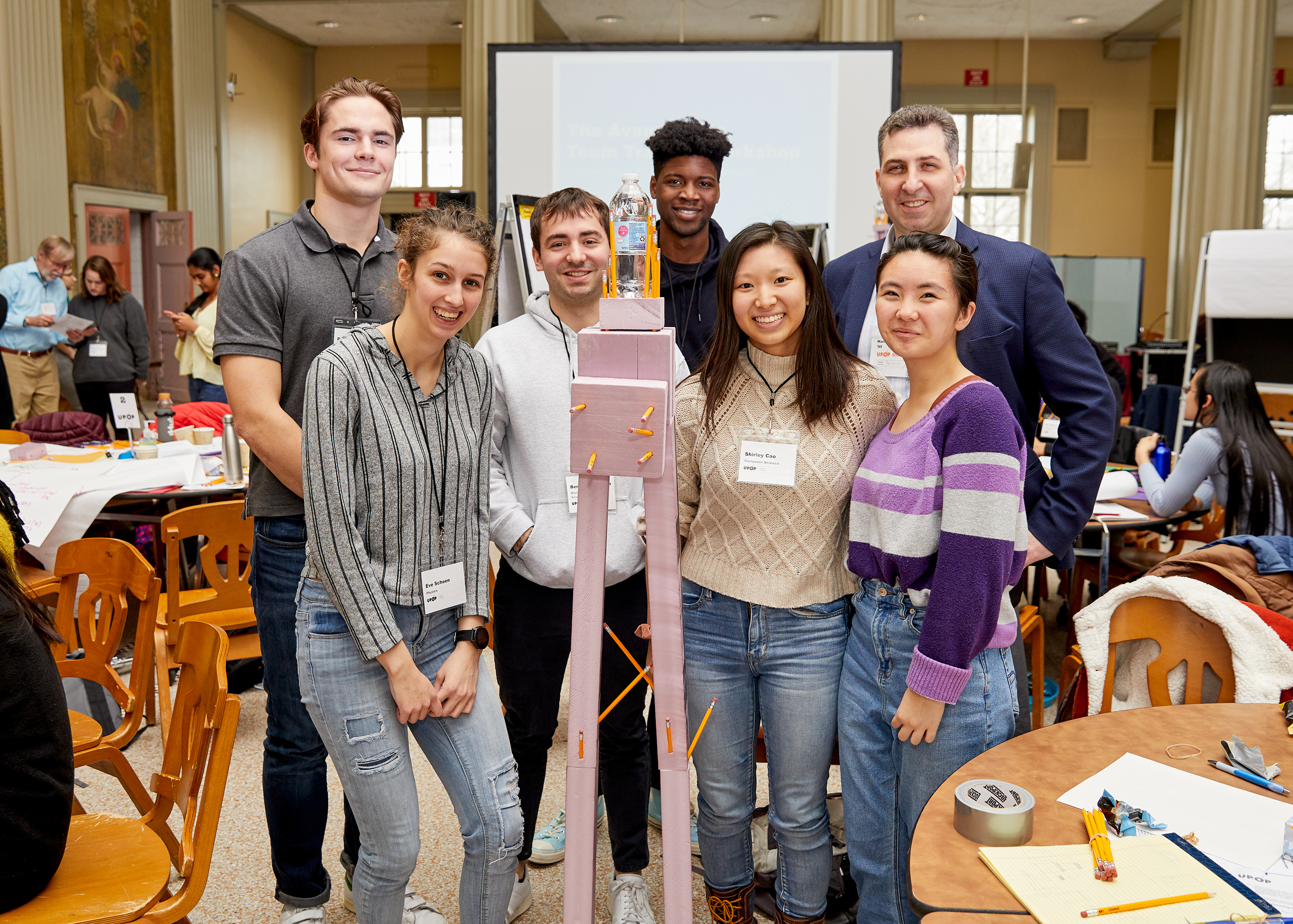 A team poses with its pencil and foam "skyscraper" during MIT UPOP's weeklong workshop