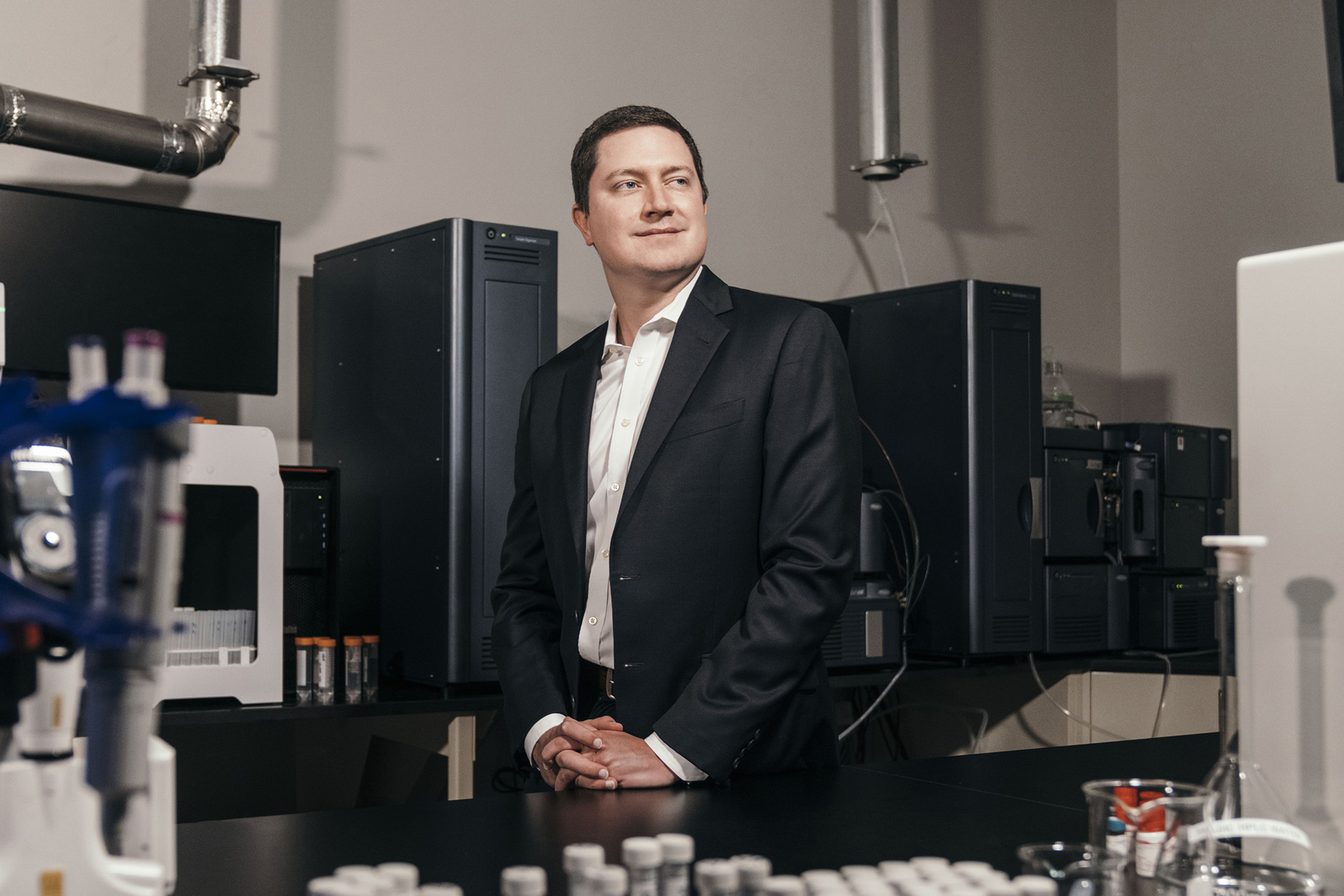 Sean Hunt stands in a room filled with lab equipment.