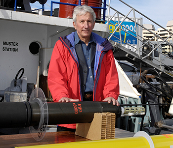 Dean Roemmich posing in front of an argo float